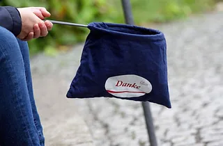 Hand hält blaue Tasche mit "Danke"-Schriftzug.